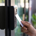 young woman using RFID tag key, fingerprint and access control  to open the door in a office building